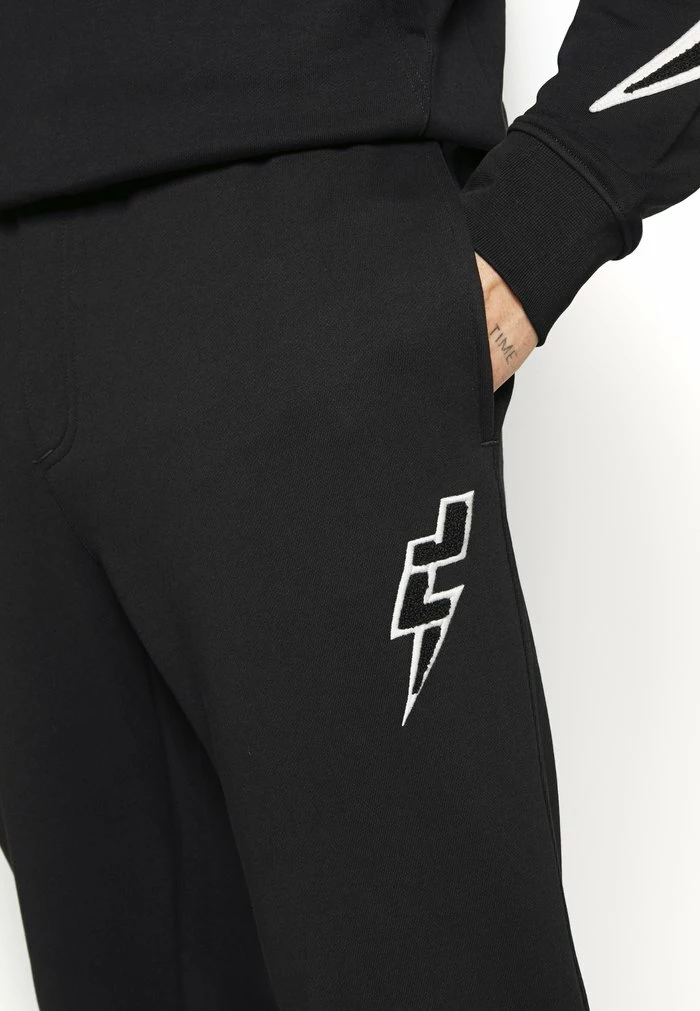 STRIKE - Tracksuit bottoms - black